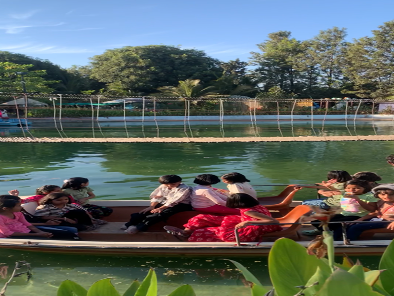 Children enjoying a boat ride on a peaceful lake surrounded by greenery